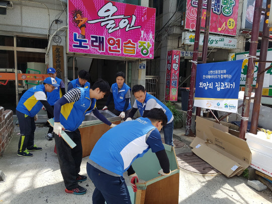 신한신용정보 직원들은 18일 부산 기장군 기장면에서 경제 상활이 어려운 채무자들을 위한 주택 개·보수 봉사활동 '따뜻한 하우스'를 실시하고 있다. 신한신용정보 제공